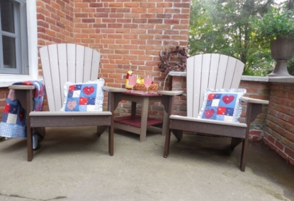 Adirondack chairs with colorful cushions and a side table, showcasing durable outdoor furniture designed for comfort and style in backyard settings.
